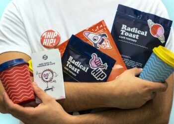 a man holding a cup of coffee and some snacks